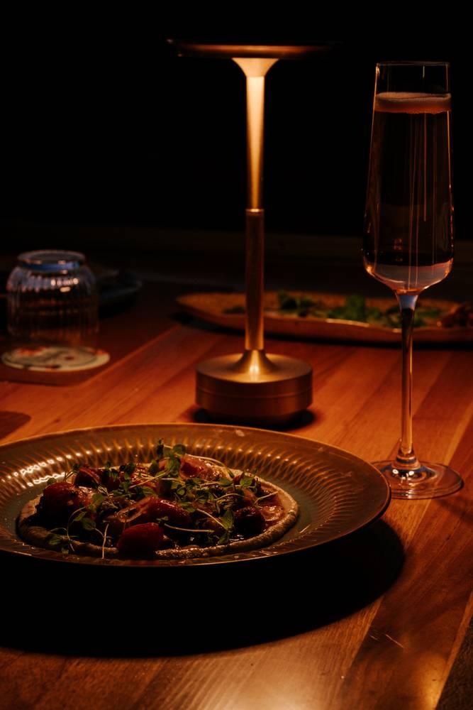 Heirloom carpaccio and sparkling wine by lamplight at Aranya Acres restaurant, Wamboin